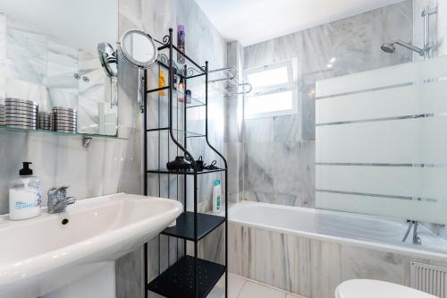 ein Badezimmer mit einer weißen Badewanne und einem Waschbecken und einer Badewanne Tubermott in der Unterkunft Studio Vista Bonita in Sitio de Calahonda