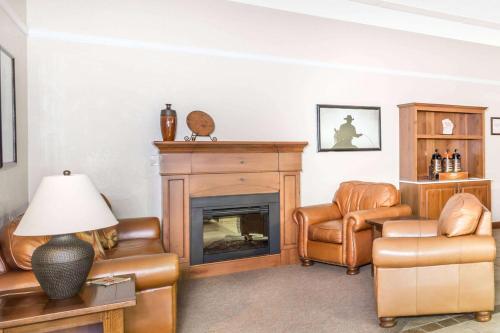 a living room with a fireplace and leather chairs at Super 8 by Wyndham Salina/Scenic Hills Area in Salina