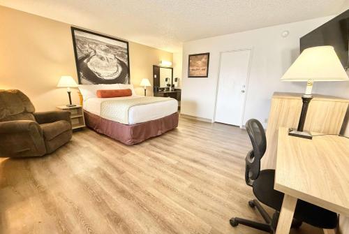a hotel room with a bed and a desk and a chair at Super 8 by Wyndham Salina/Scenic Hills Area in Salina
