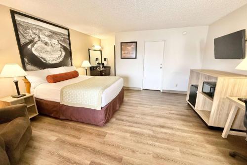 a hotel room with a bed and a flat screen tv at Super 8 by Wyndham Salina/Scenic Hills Area in Salina