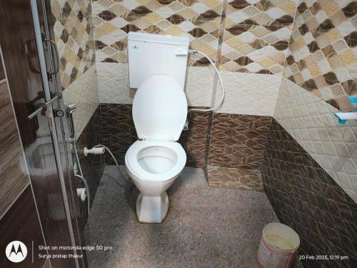a bathroom with a white toilet in a room at Homestay by Anand in Naini