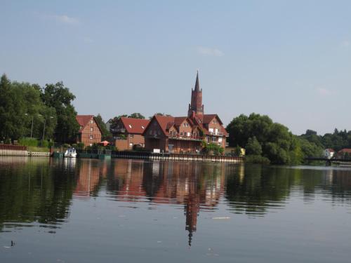 a large house sitting on the side of a lake at Havelpension in Rathenow