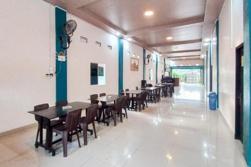 a row of tables and chairs in a restaurant at RedDoorz Syariah at Wisma Seroja Indah Duri in Duri