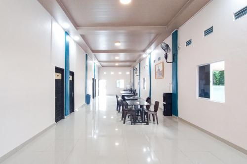 a hallway with tables and chairs in a building at RedDoorz Syariah at Wisma Seroja Indah Duri in Duri