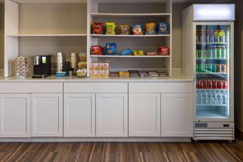 a pantry with white cabinets and a refrigerator at Baymont by Wyndham Newark at University of Delaware in Newark