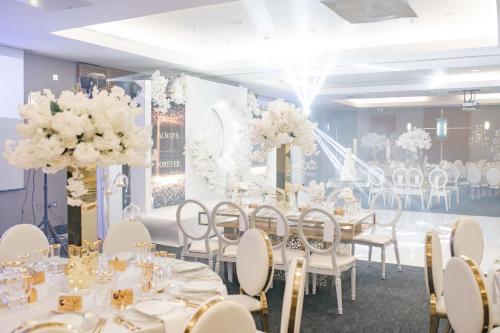 a banquet hall with white tables and chairs and flowers at Hilton London Canary Wharf in London