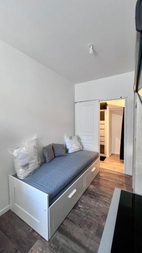 Ce lit se trouve dans un dortoir doté d'un mur blanc. dans l'établissement Studio neuf proche de la mer, à Étaples