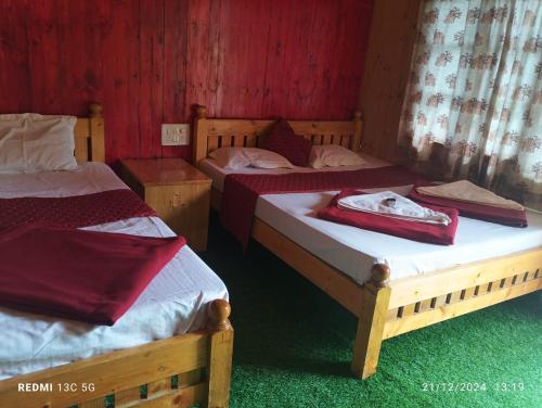 two twin beds in a room with red walls at Cheetah Farms Jungle Stay in Dandeli
