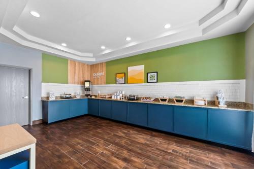 a kitchen with blue cabinets and green walls at Spark By Hilton San Antonio Near Seaworld in San Antonio