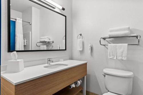 a white bathroom with a sink and a mirror at Spark By Hilton San Antonio Near Seaworld in San Antonio