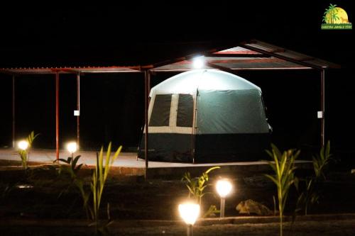 a tent is lit up at night with lights at Cheetah Farms Jungle Stay in Dandeli