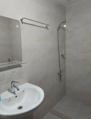 a white bathroom with a sink and a shower at Mivela Residences in Cebu City