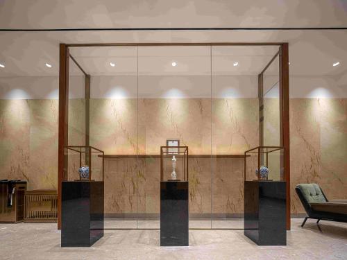 a glass wall in a room with two vases on display at Eaton Hotel Dalian Airpot & HSR Station in Jinzhou