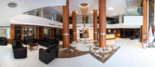 a lobby on a cruise ship with black furniture at Coral Karbala Hotel in Karbalāʼ