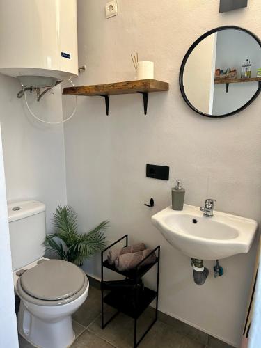 a bathroom with a sink and a toilet and a mirror at Sunshine loft in Gran Alacant