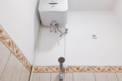 a water heater in the corner of a room with aaucet at RedDoorz at Imanuel Homestay Tomohon in Tomohon