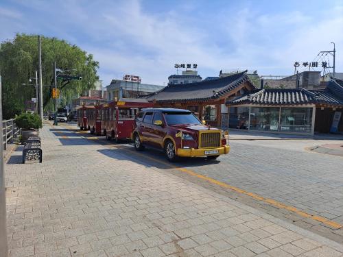 a small trolley car on a city street at HaengGung MaSil in Suwon
