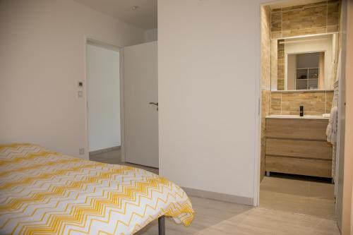 Maison de vacances Moliets et maa في موليات-إي-ما: غرفة نوم بباب يؤدي الى دورة المياه