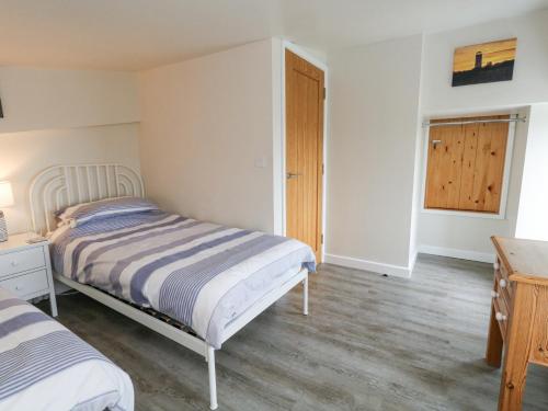 a bedroom with two beds and a wooden floor at Coastguard View in Portland