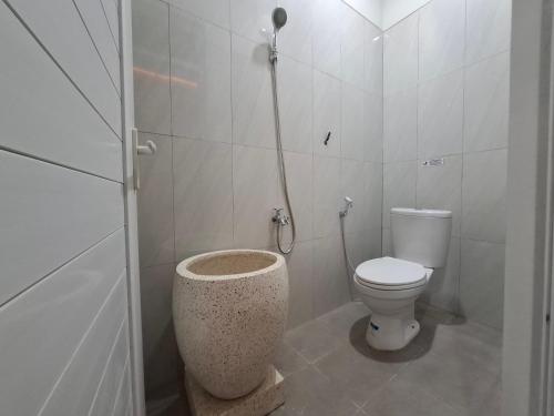 a bathroom with a toilet and a shower in it at Koala Tidur Hostel Syariah Yogyakarta in Seturan