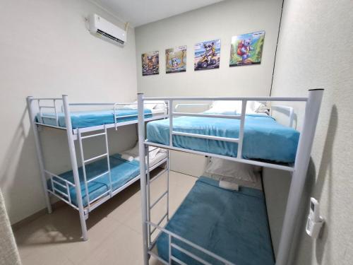 two bunk beds in a room with paintings on the wall at Koala Tidur Hostel Syariah Yogyakarta in Seturan