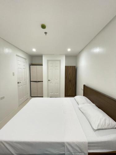 a large white bed in a room with two doors at 1 Bedroom Unit at One Pontefino Tower in Batangas City