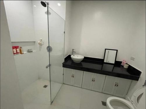 a bathroom with a shower and a sink and a toilet at 1 Bedroom Unit at One Pontefino Tower in Batangas City