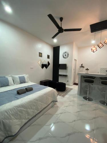 a white bedroom with a bed and a desk at D'Lamp Studio in Kampung Kuala Besut