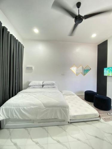 una camera da letto con un letto e un ventilatore a soffitto di D'Lamp Studio a Kampung Kuala Besut