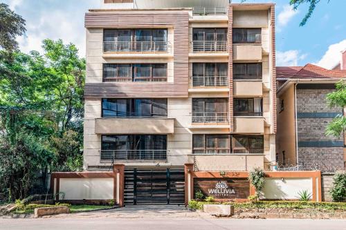 an apartment building with a garage in front of it at Wellivia Suites Serviced Apartments in Nairobi
