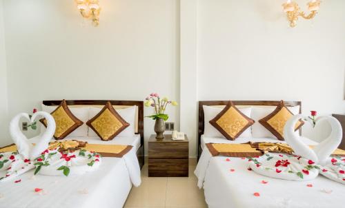 two beds in a room with swans decorations at Dat Anh Hotel in Hue