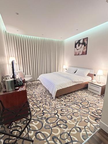 a bedroom with a bed and a table and a chair at غرفه فندقيه فاخره in Riyadh