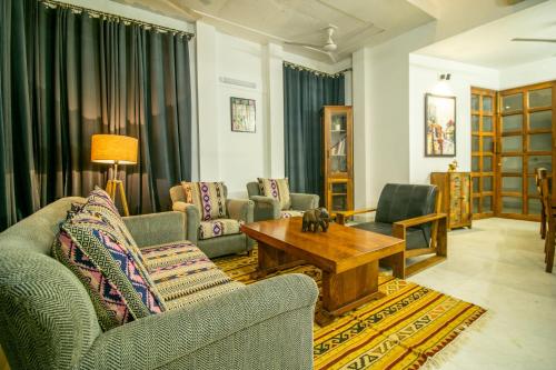 a living room with couches and a coffee table at Opulent Antique 6BR Independent Villa in Gurugram in Gurgaon