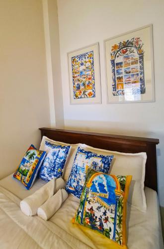 a bed with blue and white pillows on it at ArtNEST Gallery Stay , Pedlars St , Galle Fort in Galle