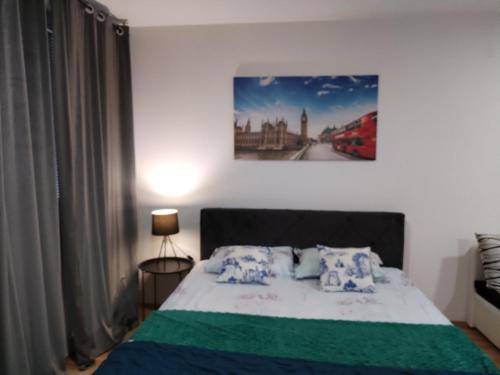 a bedroom with a bed and a painting on the wall at Apartman Lanass Doboj in Doboj
