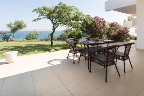 a table and chairs on a patio with a view of the ocean at Angelbay Bungalows in Agia Triada