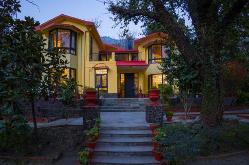a yellow house with stairs in front of it at Alaya Stays Thistle House - 4 BHK Hideaway with Gazebo & Terrace in Bhīm Tāl