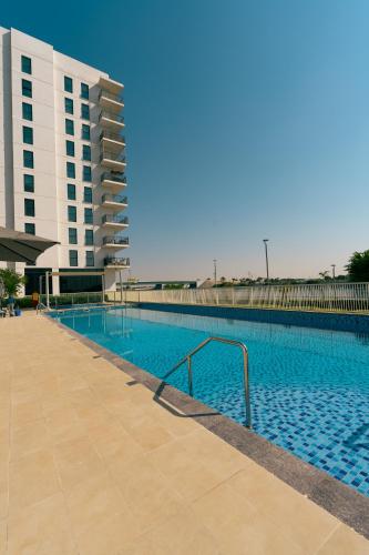 a large swimming pool next to a building at Otolo Homes with Free Yas Theme Park Tickets in Abu Dhabi