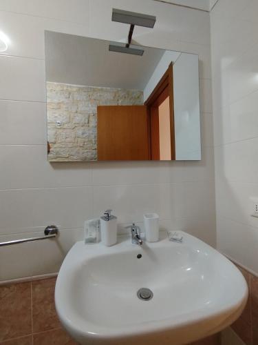 a bathroom with a white sink and a mirror at Dimora Nonno Mimì in Bitetto