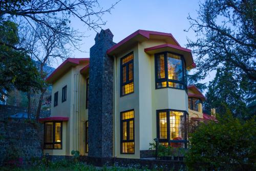 a large white house with its lights on at Alaya Stays Thistle House - 4 BHK Hideaway with Gazebo & Terrace in Bhīm Tāl