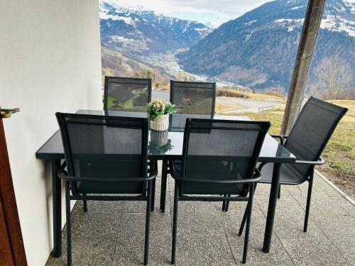 a table and chairs with a view of mountains at Flensa-Ferienwohnung in Seewis im Prättigau