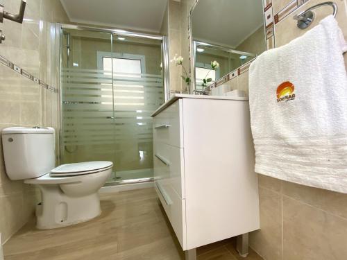 Un baño blanco con inodoro y ducha. en Antillas XIII By Solymar Holiday, en Torre del Mar