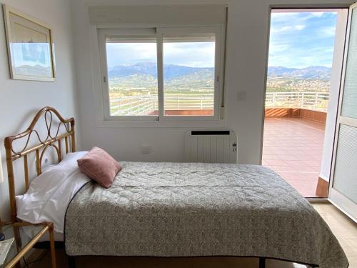 Un dormitorio con una cama y una ventana grande. en Antillas XIII By Solymar Holiday, en Torre del Mar