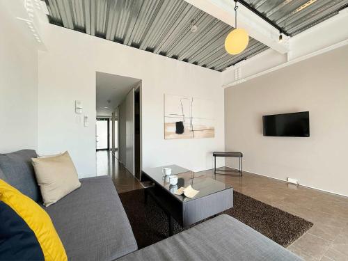ein Wohnzimmer mit Sofa und Fernseher in der Unterkunft b hotel Komachi 1 BR Apartment Free Breakfast Included in Hiroshima