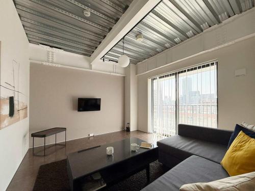 ein Wohnzimmer mit Couch und großem Fenster in der Unterkunft b hotel Komachi 1 BR Apartment Free Breakfast Included in Hiroshima
