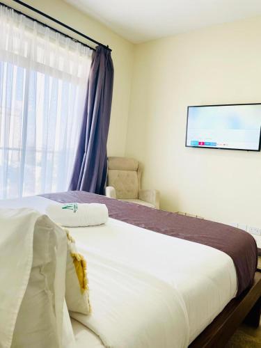 a bedroom with a large bed with a window at Silverstone Apartments Nairobi, Kilimani in Nairobi