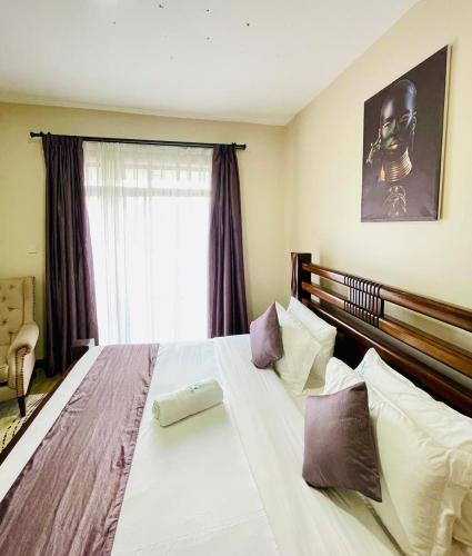 a bedroom with a large white bed with a window at Silverstone Apartments Nairobi, Kilimani in Nairobi