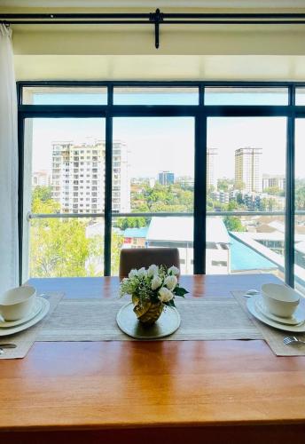 a table with a vase of flowers on top of it at Silverstone Apartments Nairobi, Kilimani in Nairobi