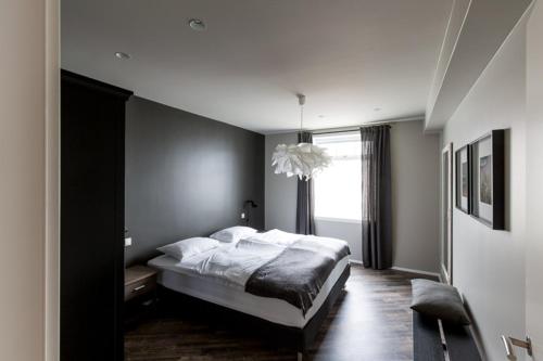 a bedroom with a large bed and a window at Acco Luxury Apartments in Akureyri