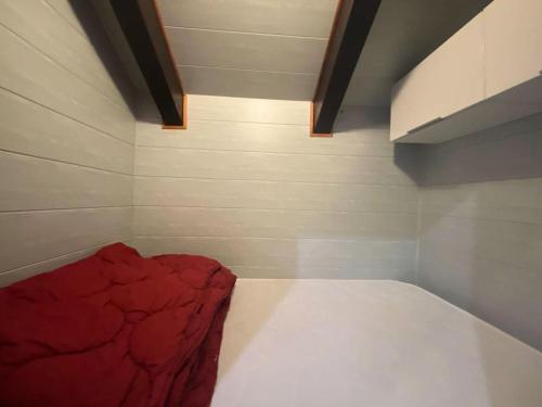 une petite pièce avec un lit rouge dedans dans l'établissement Résidence Diamant 1 - Joli appartement de 3 couchages dans le cœur de la station des Deux Alpes MAE-2311, à Vénosc